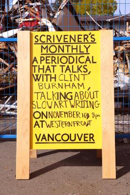 A yellow sandwich board reading Scrivener's Monthly a periodical that talks, with Clint Burnham talking about slow art writing on November 16th at 8pm at Western Front, Vancouver. The text is written in black capital letters. Th sign is positioned outside in front of a blue temporary fence that partitions off a demolished building. 
