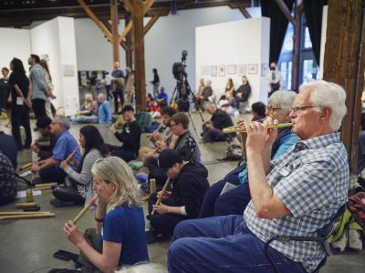 Seated in rows, participants blow into ongiyongs. Every other person plays a different note. 