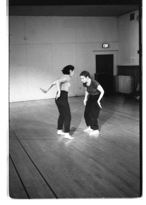 A black-and-white photo showing Denise Fujiwara and Paula Ravitz dancing. They’re barefoot and wear t-shirts and sweatpants.