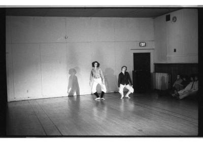 A black-and-white photo of Jennifer Mascall and Susan McKenzie standing in a relaxed plié with their arms flopped along their sides.