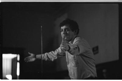 Joel Chadabe stands with his arms out wide with his palms facing in towards a theremin. The photo is black and white.