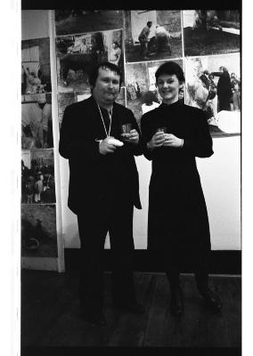 Hermann Nitsch and Jane Ellison stand in front of a photographic installation documenting the ritual mutilation of a nude body.