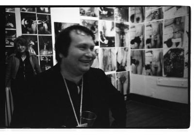 Herman Nitsch smiles while standing in front of his photographic installation in Western Front’s gallery. 