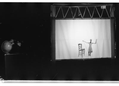 A portable shadow theatre depicts a shadow puppet figure and a shadow puppet chair.
