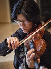 A portrait shot of Alissa Cheung playing violin.